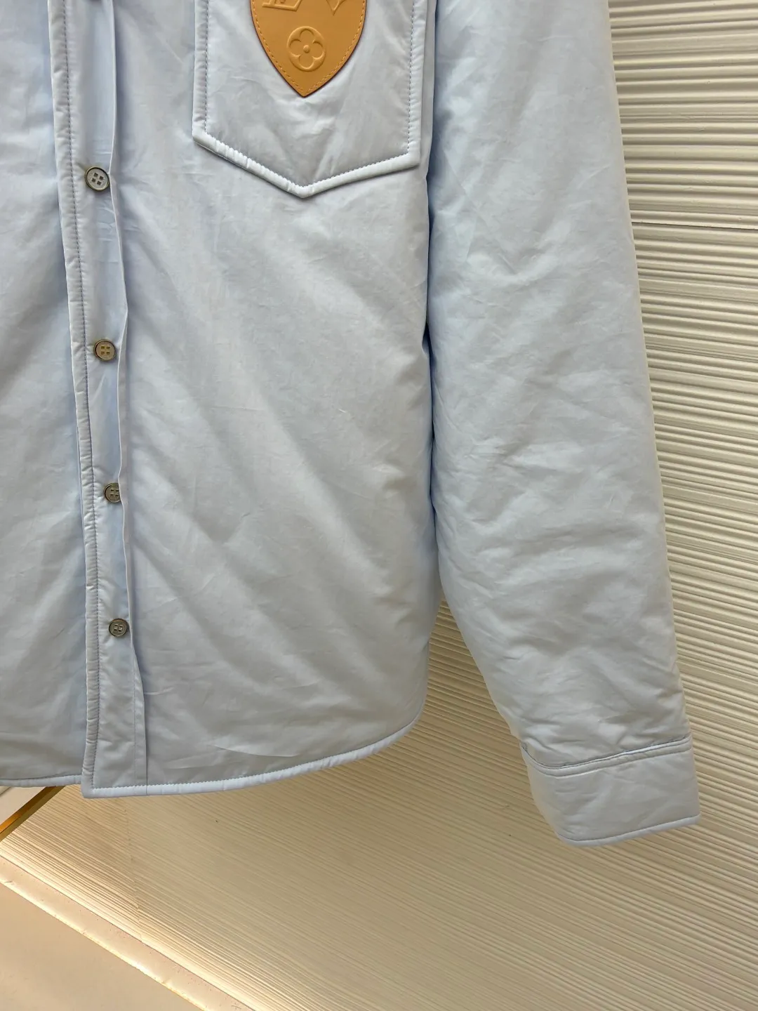 LOUIS VUITTON SKI Ski Series Lightly padded cotton long-sleeved cotton jacket ●Original version: Purchased and developed by 22889 ●Item number: 1682102-B25 ●Fabric: 100% cotton fabric ●Technology: Positioned cutting machine ●Color: blue ●Version: fitted version ●Weight: about 810 grams ●Size: S-M-L-XL ●Description: This Louis Vuitton shirt-style jacket is made of high-count combed cotton blend fabric. It has been pre-washed and treated with water to achieve a soft and skin-friendly feel, while also giving the fabric anti-wrinkle and easy care properties. The body of the garment is filled with a thin layer of warm cotton using quilting technology. The stitches are fine and even and arranged in a regular rhombus pattern, which not only ensures warmth but also prevents cotton batting from clumping and shifting. The front pocket is inlaid with a first-layer cowhide embossed badge. The LV classic logo is combined with the shield-shaped outline and is made through a heat-pressing shaping process. The edges are polished smooth and burr-free. The placket uses natural horn buttons, which are double-fastened with metal snaps to increase durability. The shoulders and side seams use hemming stitching technology, and the lines are neatly and symmetrically routed. The overall cut is a loose shirt silhouette, and every splicing is precisely aligned, showing the brand's exquisite clothing craftsmanship and details. The overall wiring is straight and delicate, the fabric is comfortable and soft, and the color is consistent without color difference. It can be matched with the same style to create a fashionable look and control various occasions. Customized accessories, complete with three standards, same style for men and women!